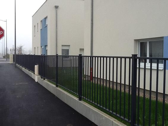 Une clôture en métal devant un bâtiment