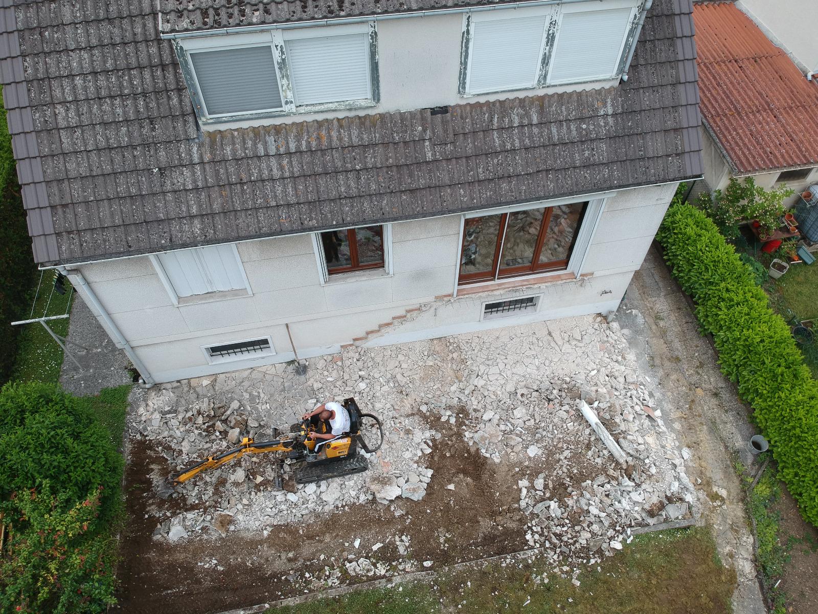 Démolition d'une terrasse avec une pelle sur chenille