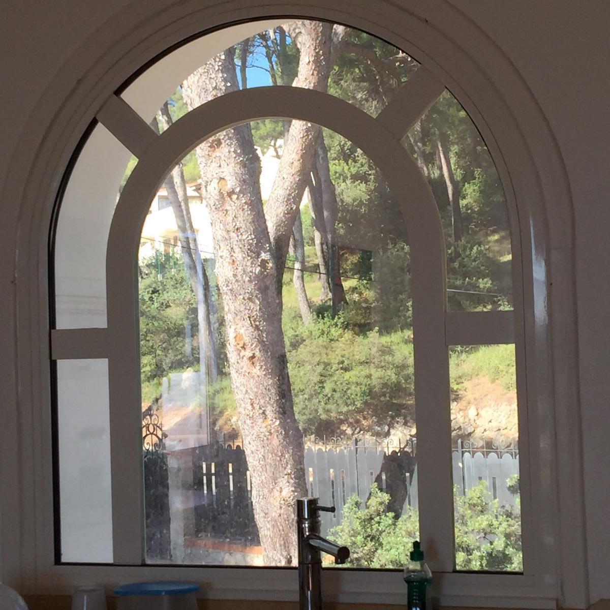 Fenêtre cintrée donnant sur un cadre verdoyant