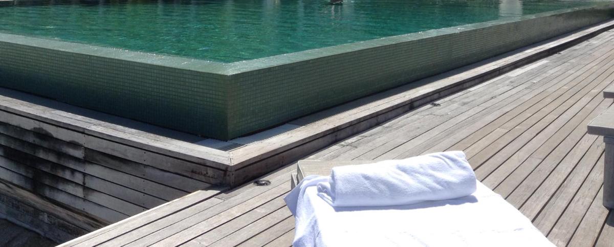 Piscine avec terrasse en bois et bain de soleil