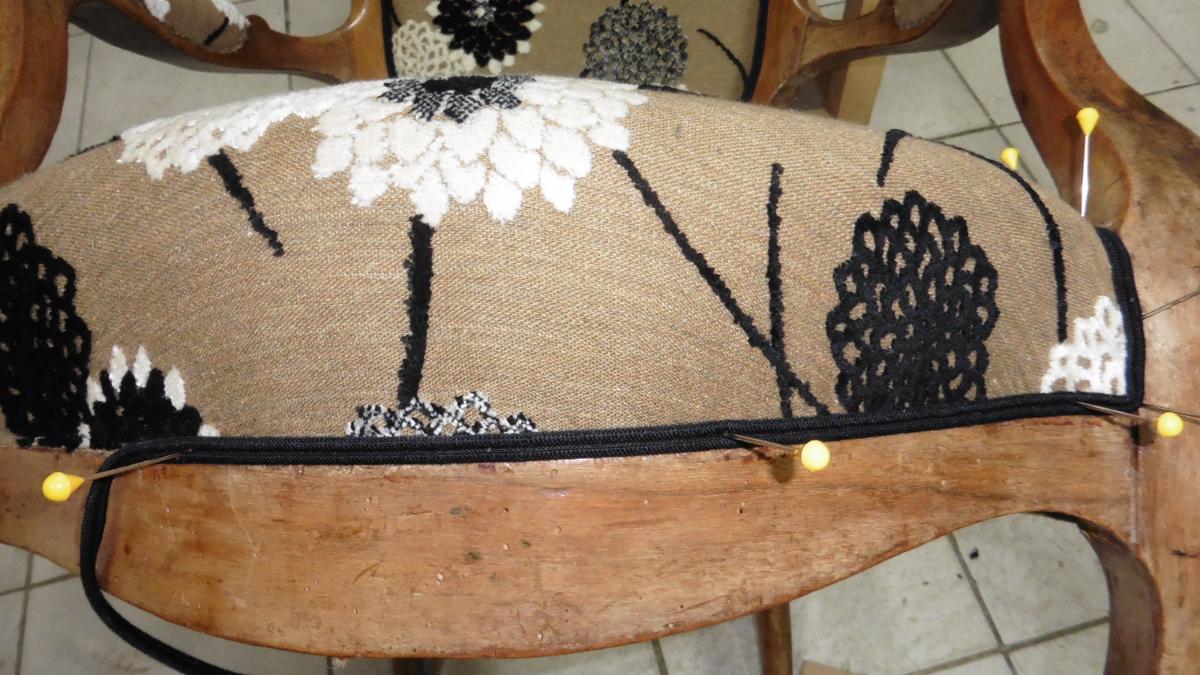 Piquage de la couverture florale sur le devant de l'assise du fauteuil Louis Philippe