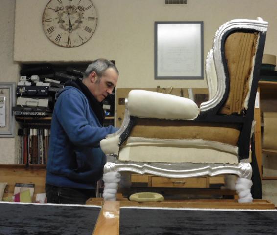 RESTAURATION TRADITIONNELLE - L'artisan travaille sur un fauteuil blanc