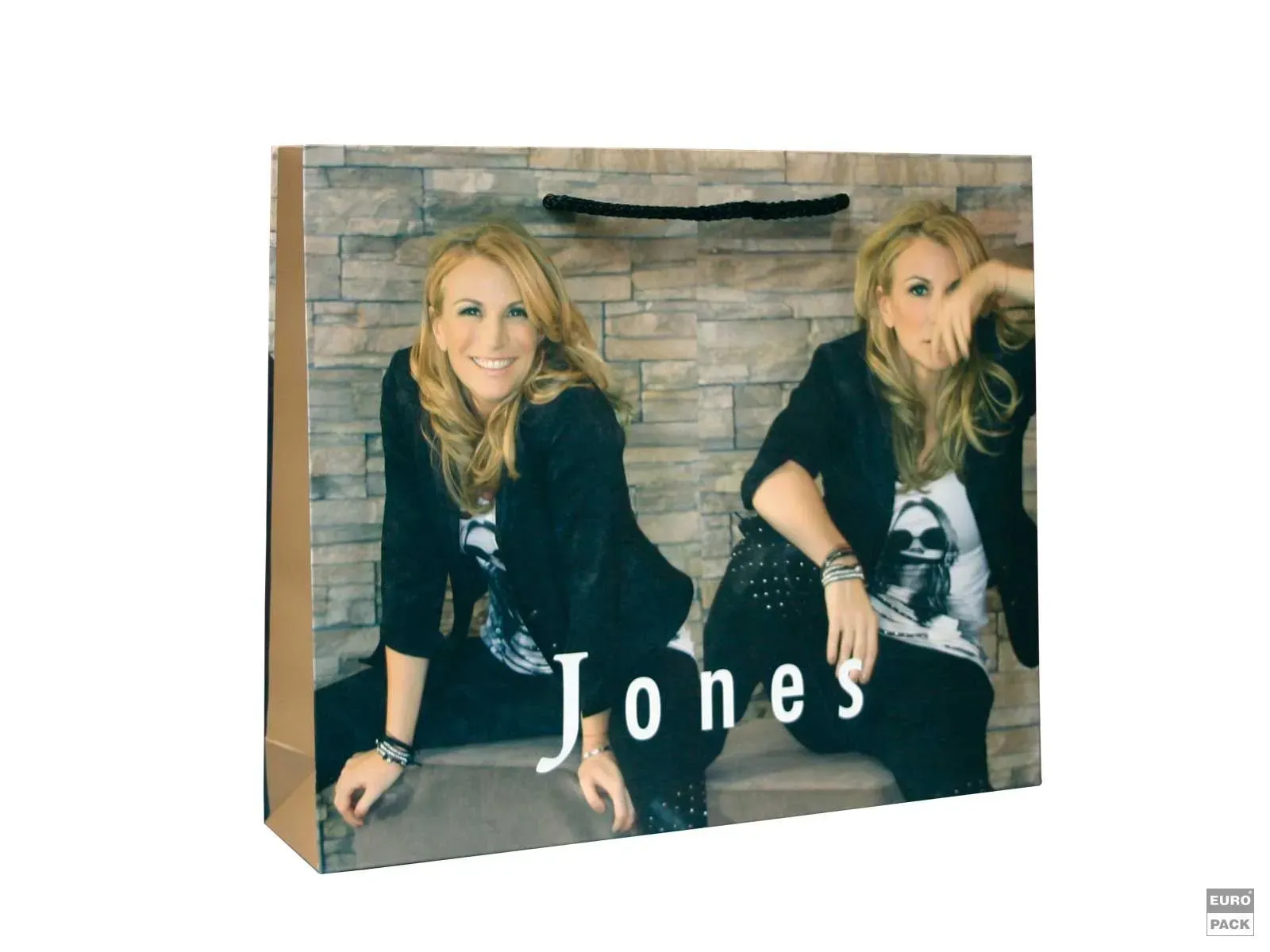 Einkaufstasche mit zwei blonden Frauen, „Jones“-Logo, die vor einer Backsteinmauer sitzen.