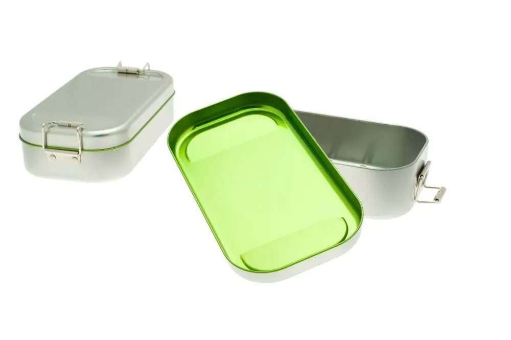Silberne Lunchboxen aus Metall, eine davon offen mit grünem Deckel, vor weißem Hintergrund.