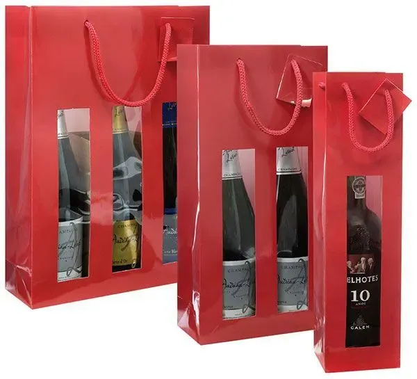 Rote Geschenktüten mit Weinflaschen, die durch klare Fenster sichtbar sind.