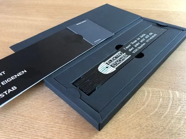 Schwarze Geschenkbox mit Lesezeichen, Karte und Umschlag.