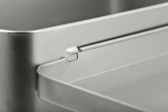 Nahaufnahme des Deckels und des Körpers einer Metalldose mit Scharnier und Riegel.