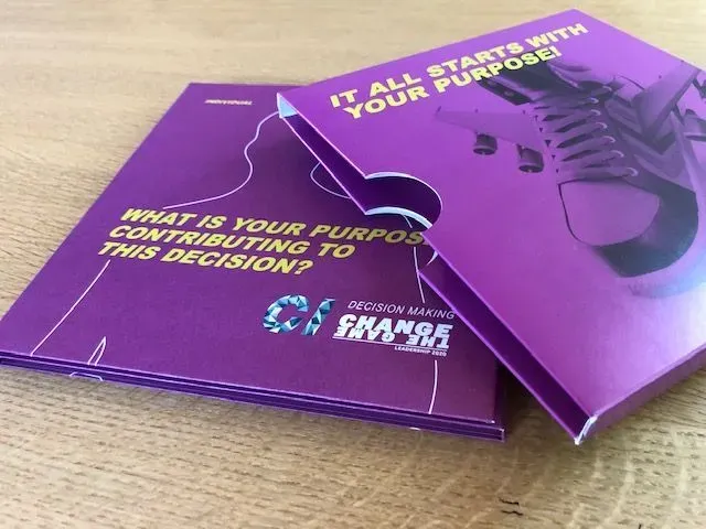 Lilafarbenes Kästchen mit dem Text „Welcher Zweck trägt zu dieser Entscheidung bei?“. Ein weiteres Kästchen mit einem Schuh und dem Text „Alles beginnt mit Ihrem Zweck!“