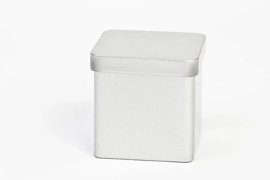 Silberne quadratische Blechdose auf weißem Hintergrund.