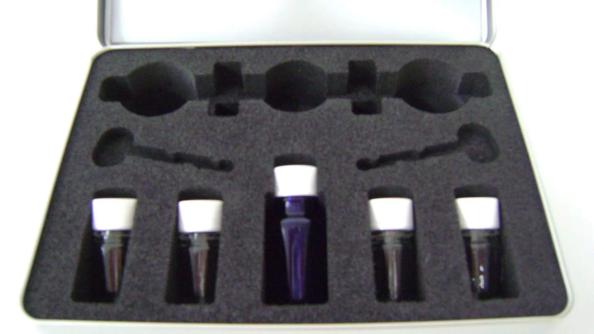 Ein Metallkoffer mit Schaumstoffeinlage, in dem sich Fläschchen mit Flüssigkeiten und Pipettenwerkzeuge befinden.