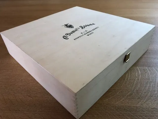 Holzkiste mit Logo auf der Oberseite.