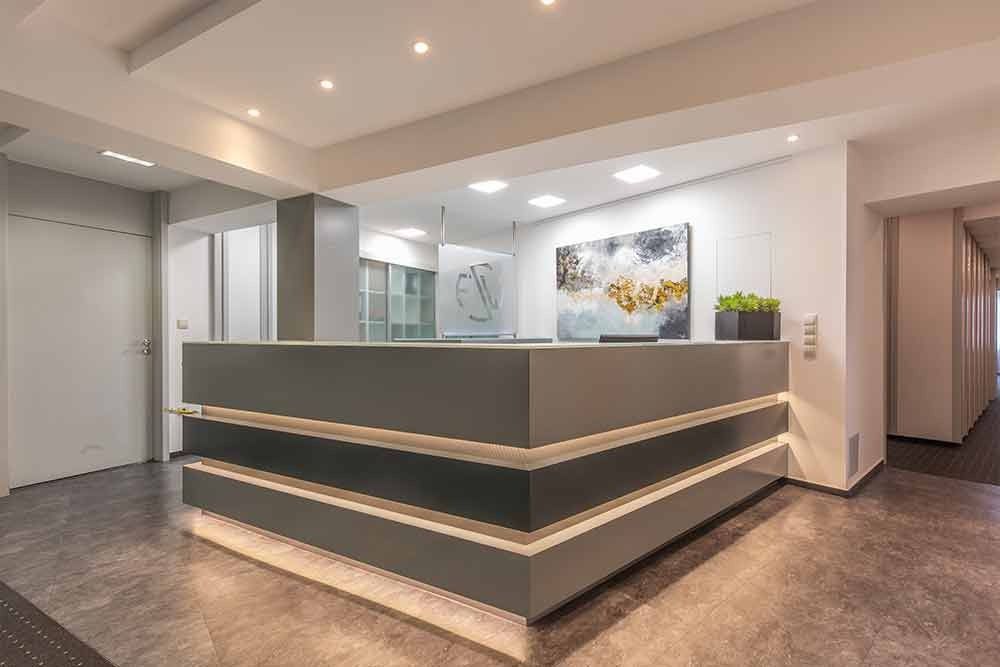 Ein Empfangstresen in einem Krankenhaus mit einem Gemälde an der Wand.