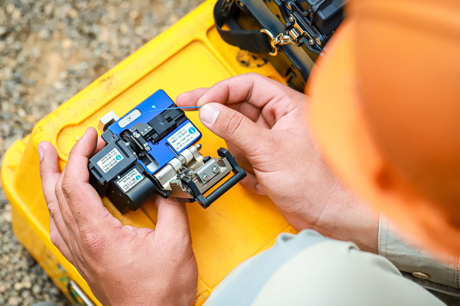 ein Kabelschneider liegt auf einem Holztisch neben verschiedenfarbigen Kabeln