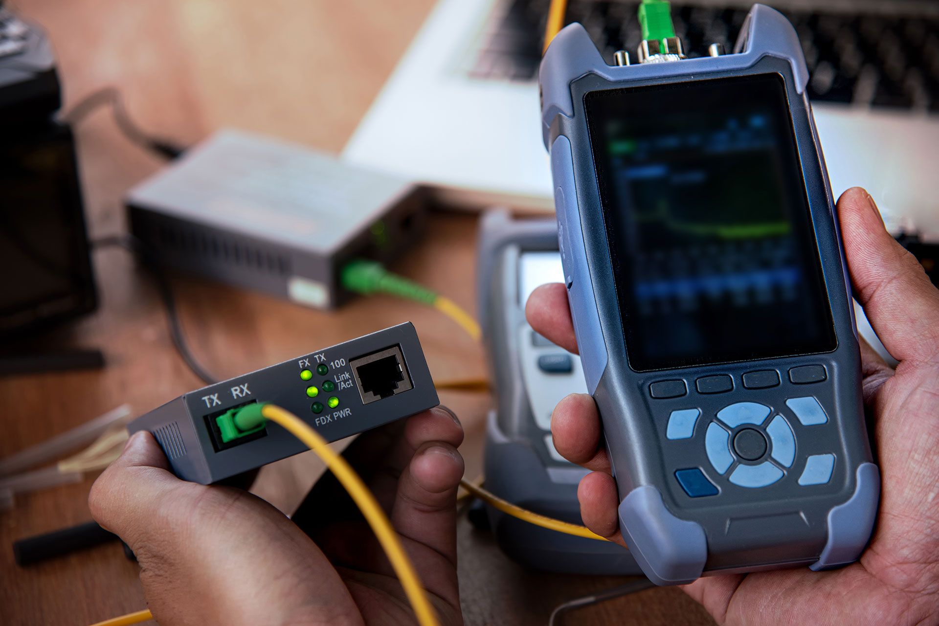 ein Mann arbeitet an einer Steckdose mit einem gelb-schwarzen Messgerät