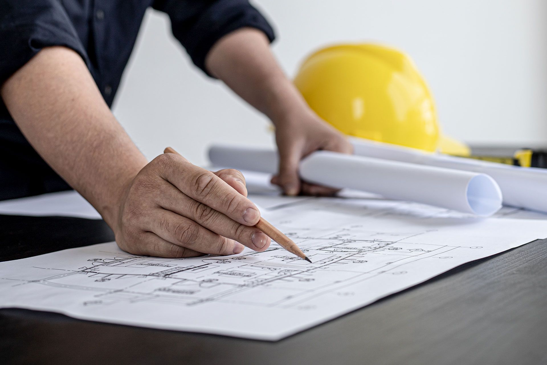 ein Mann sitzt auf einem orangefarbenen Kran und arbeitet an einem Strommast