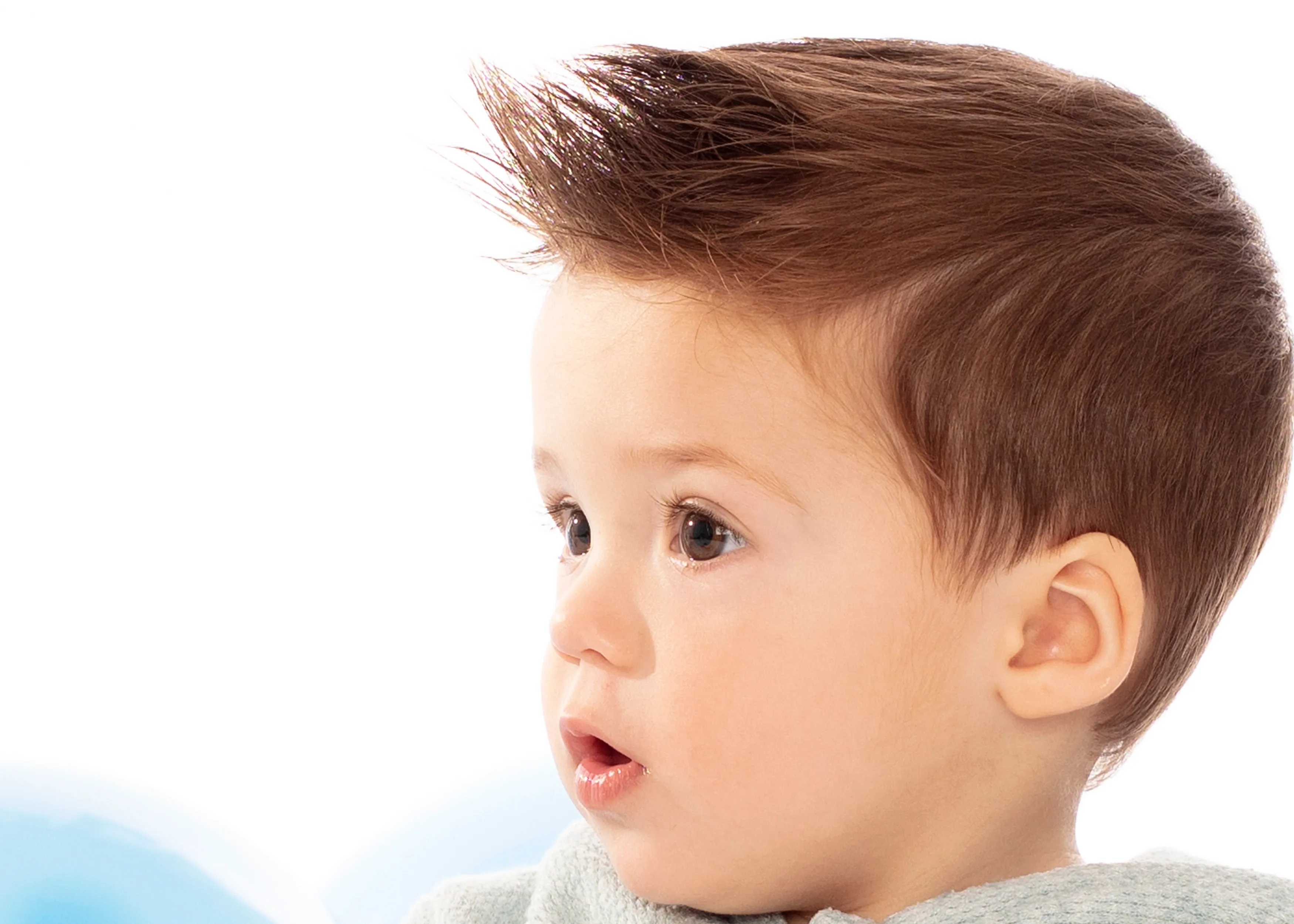 Niño con cabello castaño peinado hacia arriba, con expresión de sorpresa, piel clara, de perfil.