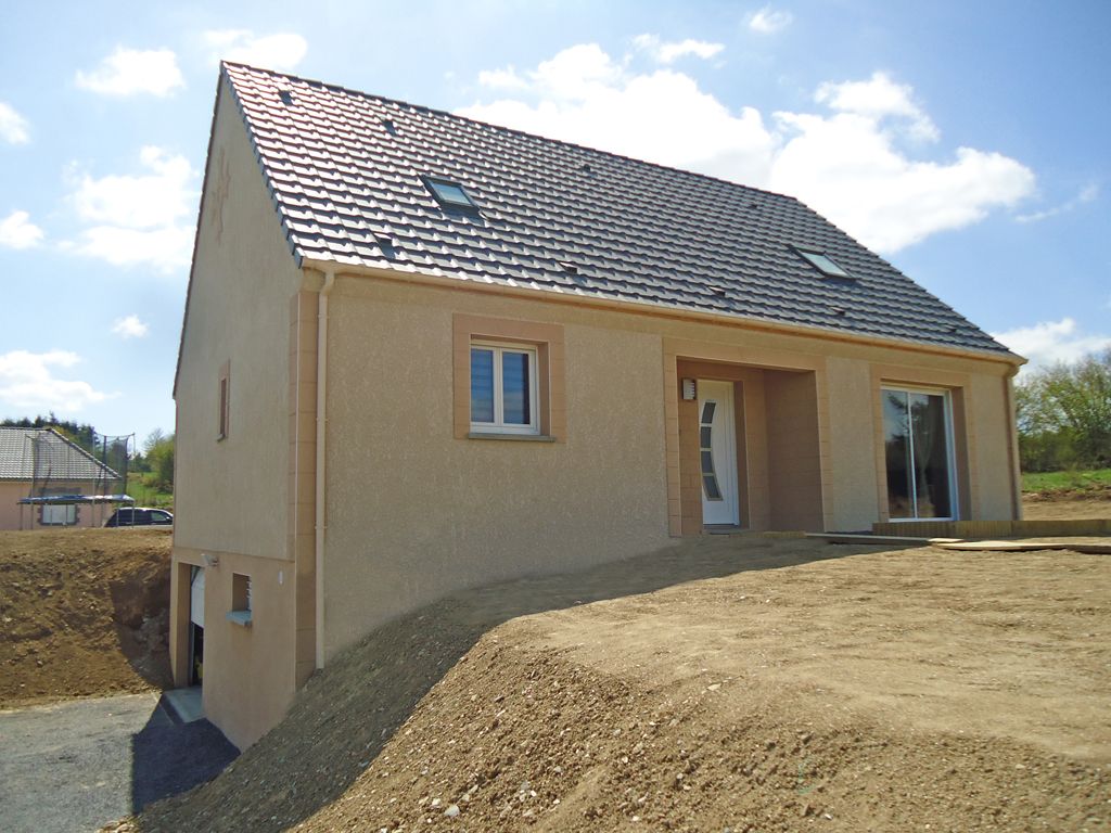 Maison beige avec toit gris foncé et deux puits de lumière, par une journée ensoleillée. Un monticule de terre devant.