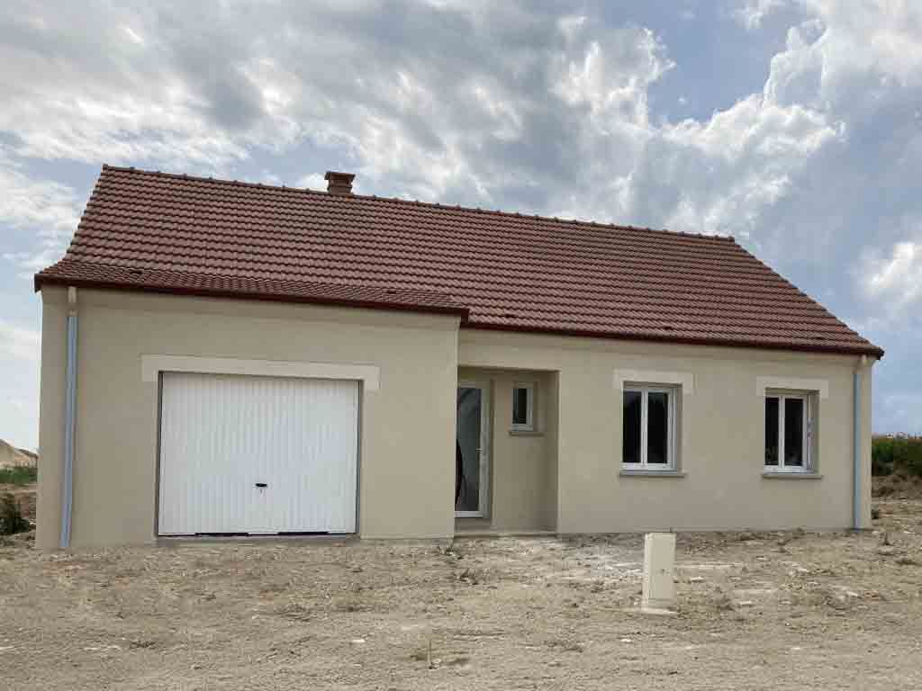 Maison beige avec toit en tuiles rouges, garage et deux fenêtres, sous un ciel nuageux.