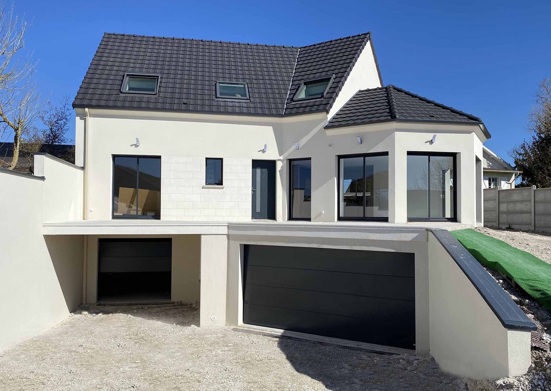 Maison de façade avec toit foncé et étage