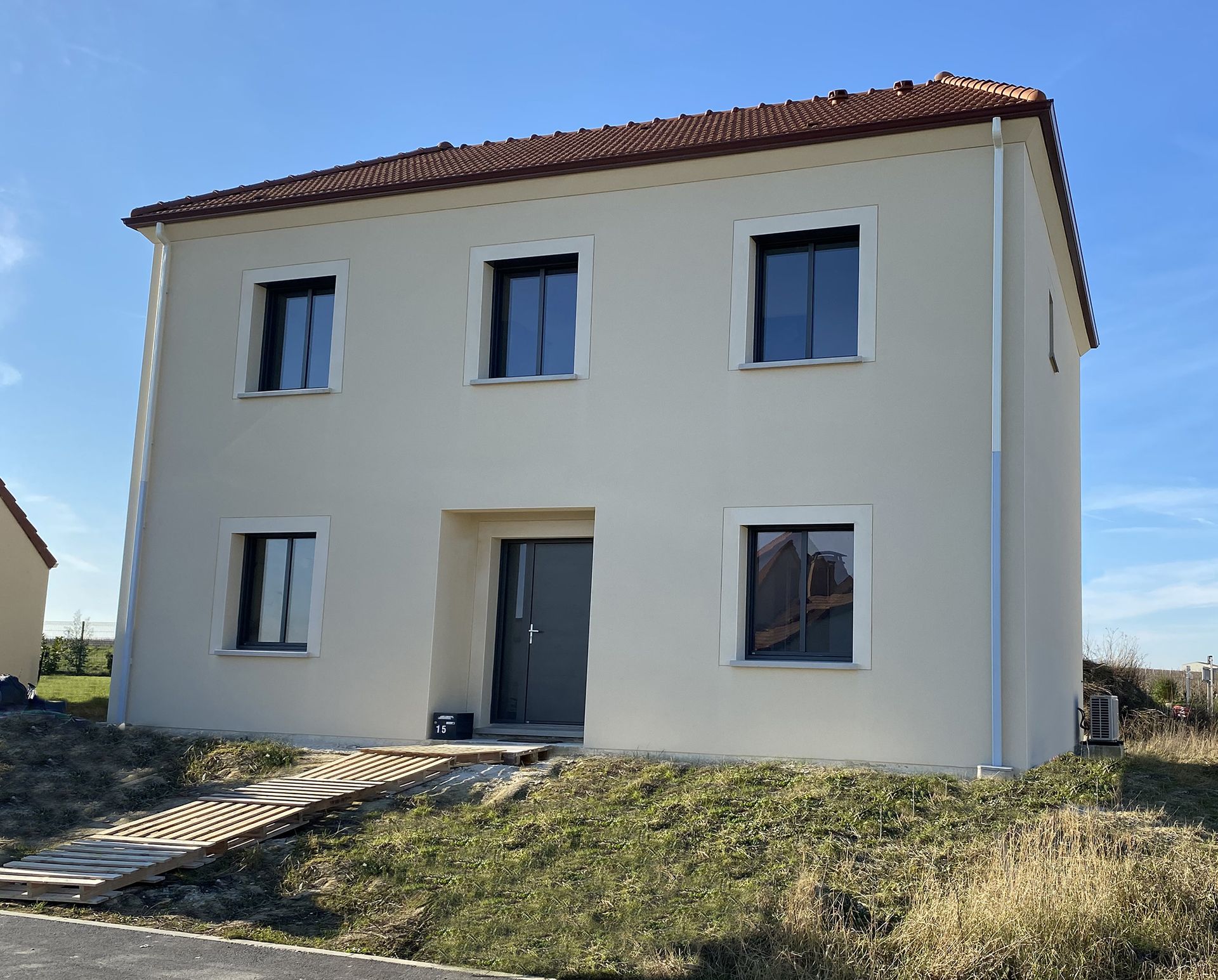 Façade d'une maison neuve avec trois fenêtres à l'étage