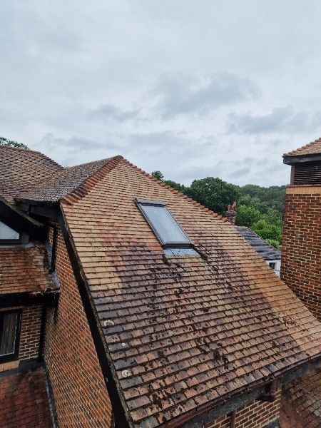 Red tiled rooftops with a skylight under a cloudy sky