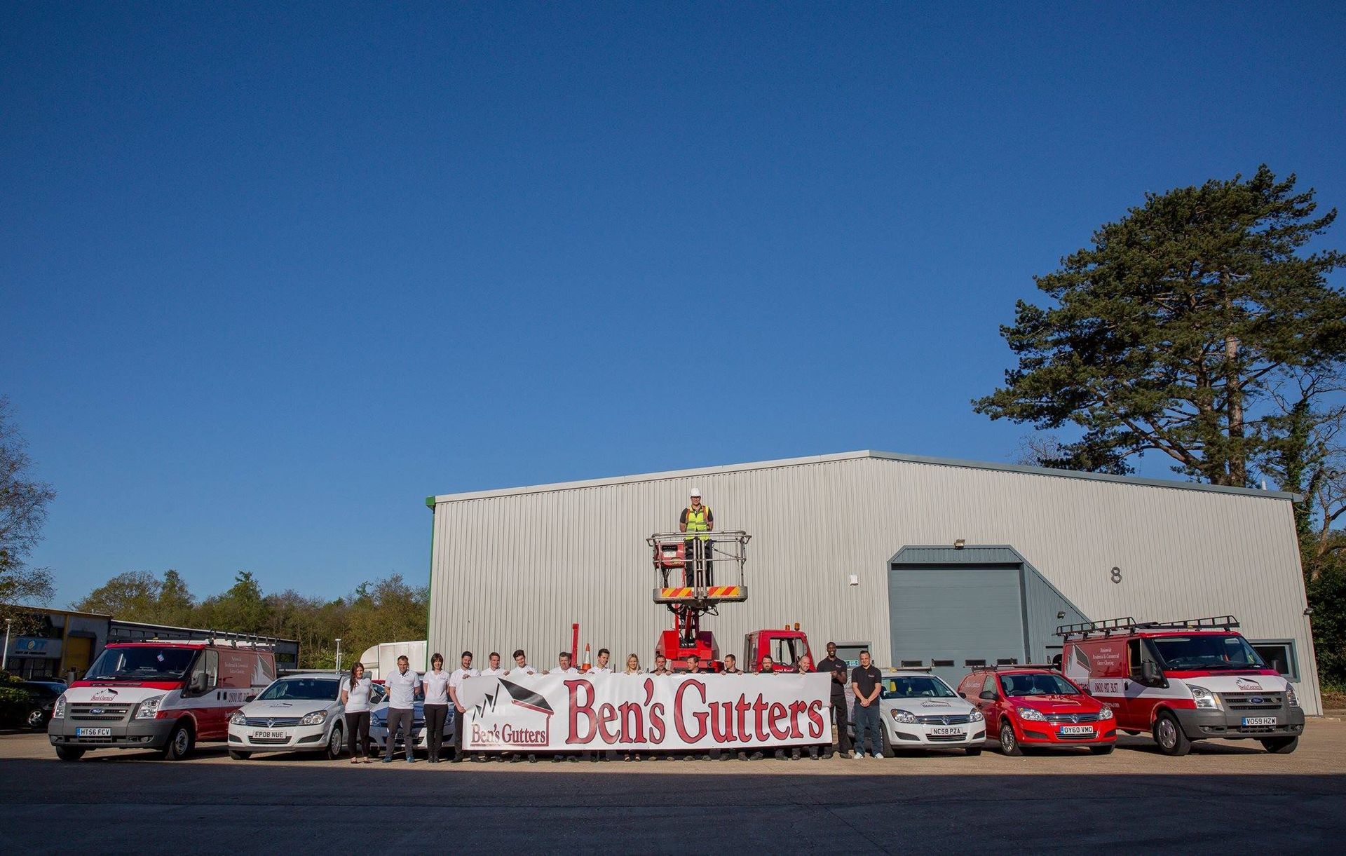 Ben’s Gutters service building with trucks parked outside under a clear blue sky