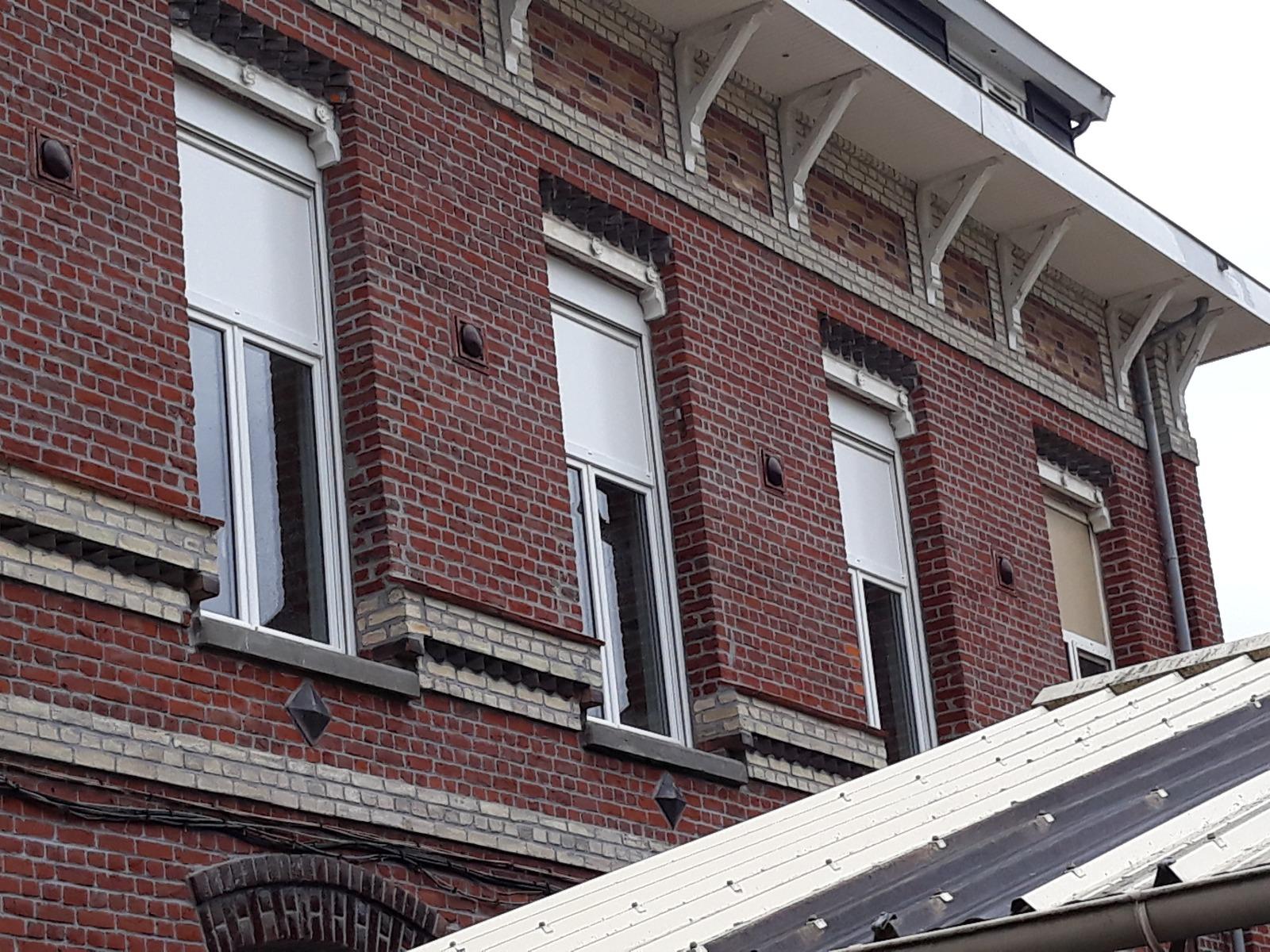Façade en brique avec fenêtres PVC munies d'impostes