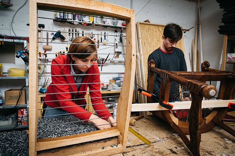 Ein Mann und eine Frau arbeiten an einem Stück Holz