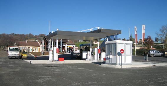 Station-service avec auvent au-dessus des pompes ; guichet du pompiste à droite.