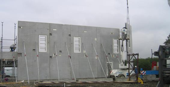 Construction d'un mur en béton avec étais et grue.
