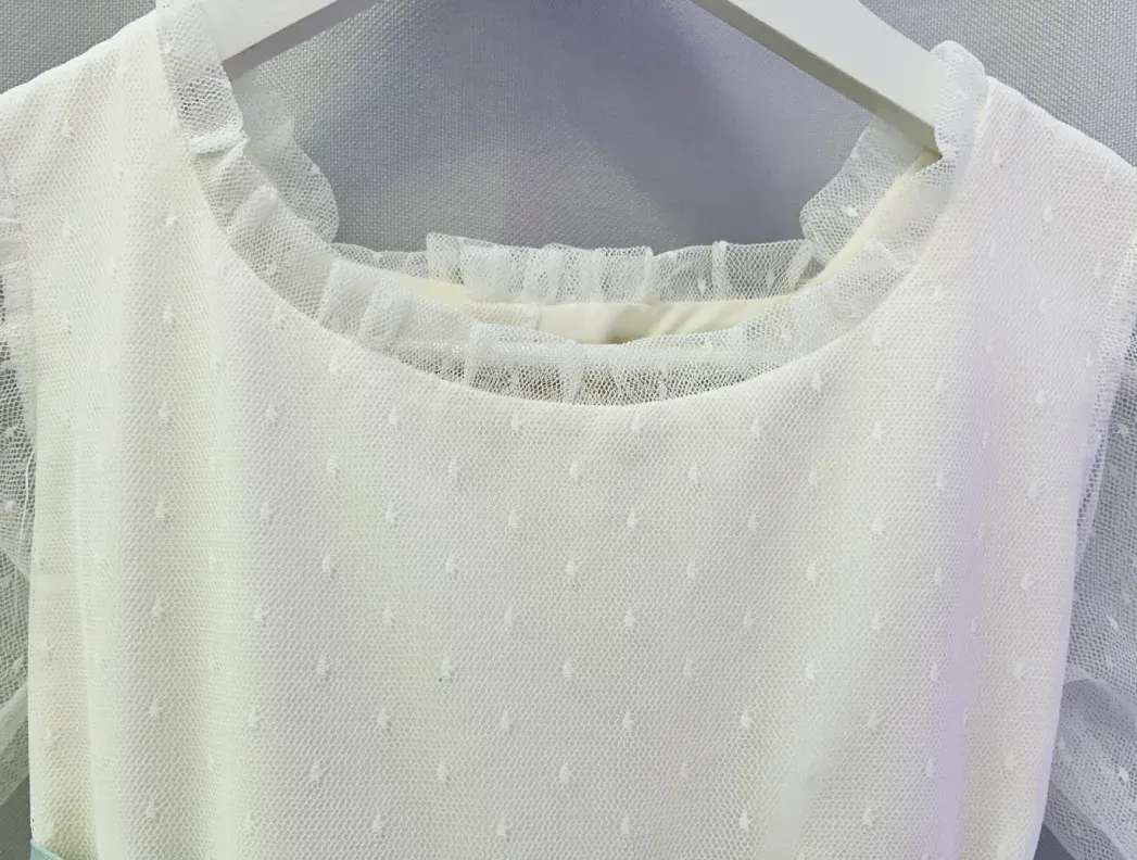 Un vestido blanco cuelga de una percha blanca.
