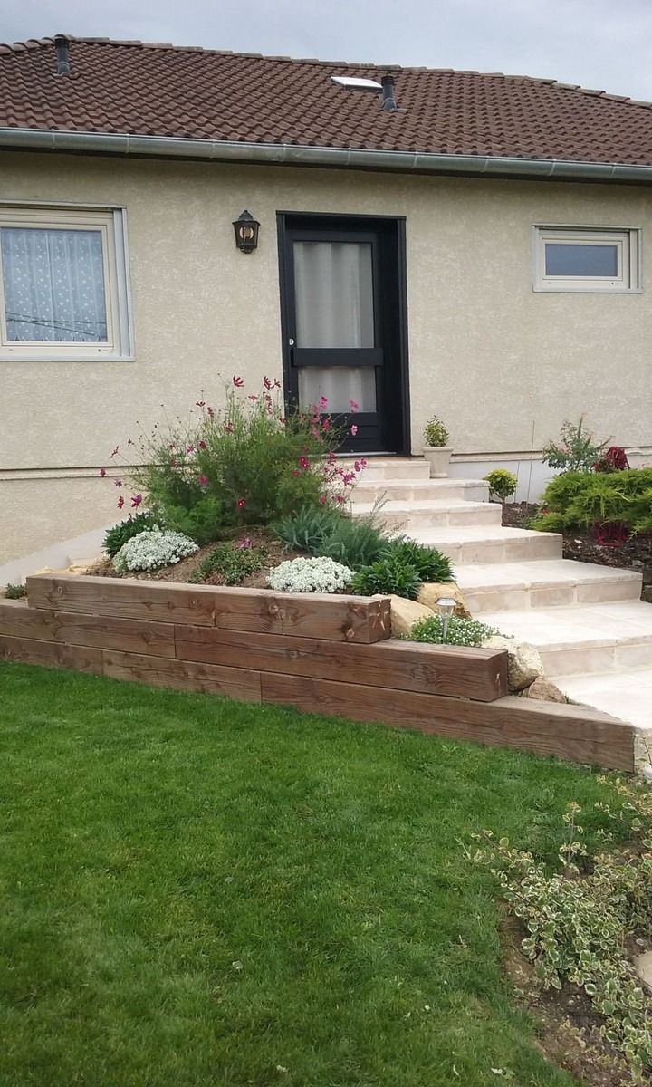Talus décoratif retenu par des poutres en bois à côté d'un escalier en pierre