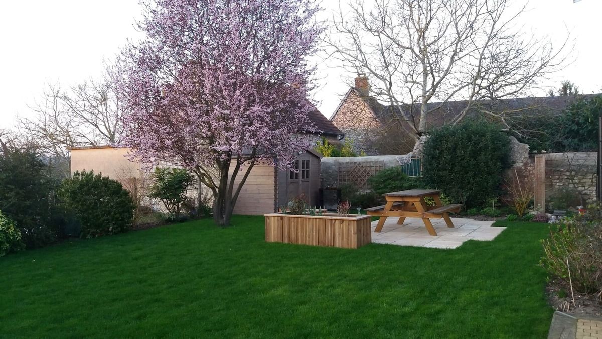 Table de pique-nique dans un espace vert tondu entouré par des arbres