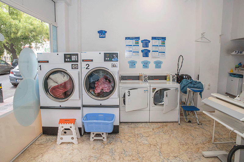 Πλυντήριο ρούχων με πλυντήριο ρούχων, στεγνωτήριο και σιδερώστρα.