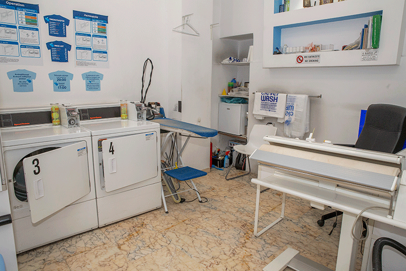 Πλυντήριο ρούχων με πλυντήριο ρούχων, στεγνωτήριο, σιδερώστρα και εκτυπωτή.