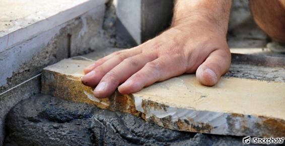 L'ouvrier en maçonnerie procède à la pose du dallage