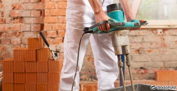 Le maçon mélange le ciment ou le béton à l'aide d'un malaxeur