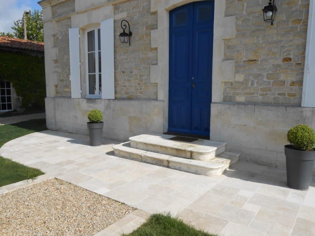 Pierre travertin pour perron d'un maison avec porte bleue