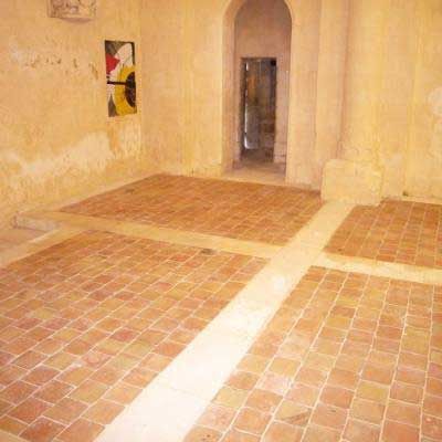 Pièce beige vide avec sol en carrelage de terre cuite et porte au fond