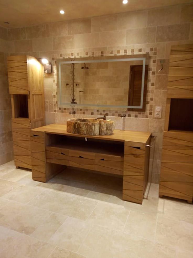 Pose de travertin dans une salle de bain avec des meubles en bois clair