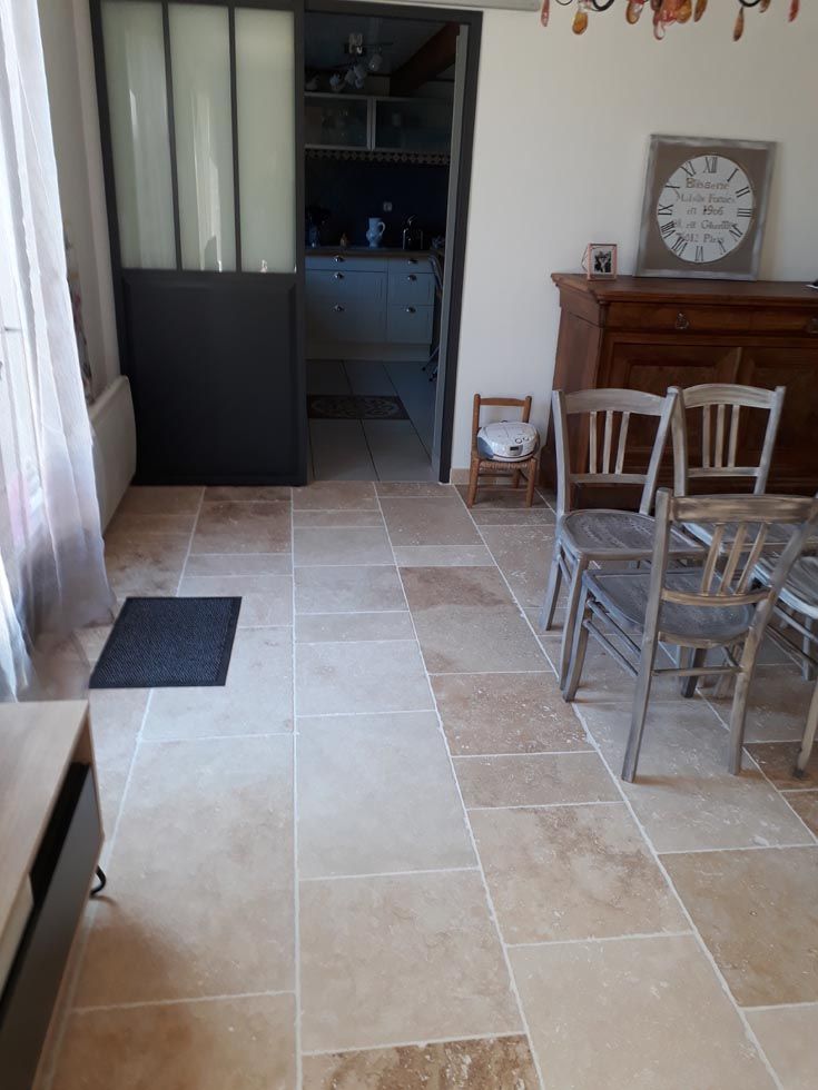 Pose de travertin bandes libres dans une cuisine avec porte coulissante noire