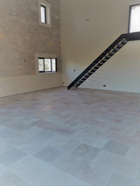 Travertin nuance 2 pour grande pièce à vivre avec haut plafond et escaliers