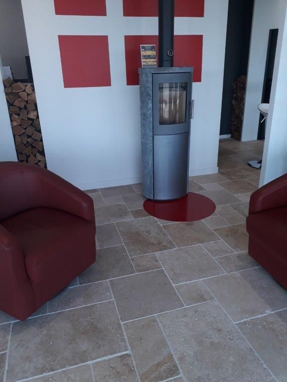 Travertin opus 13 pour salon avec poêle et décors rouges
