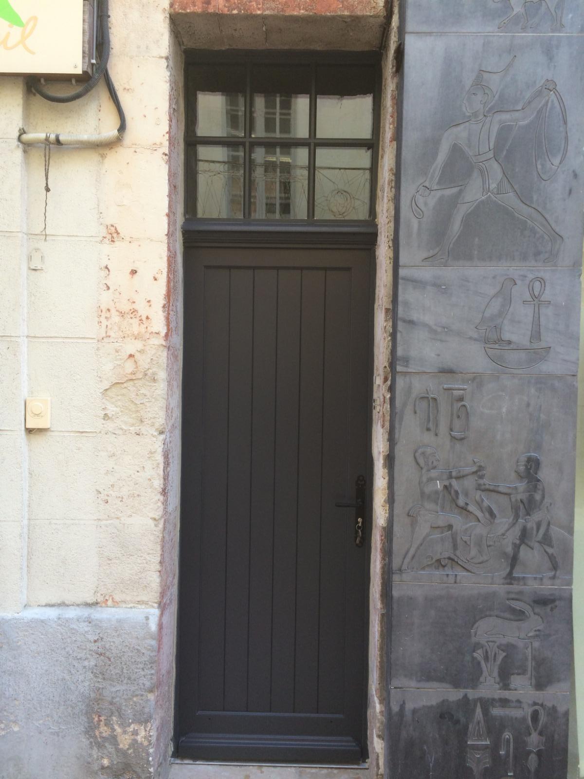 Porte en bois noir avec fenêtre sur le dessus