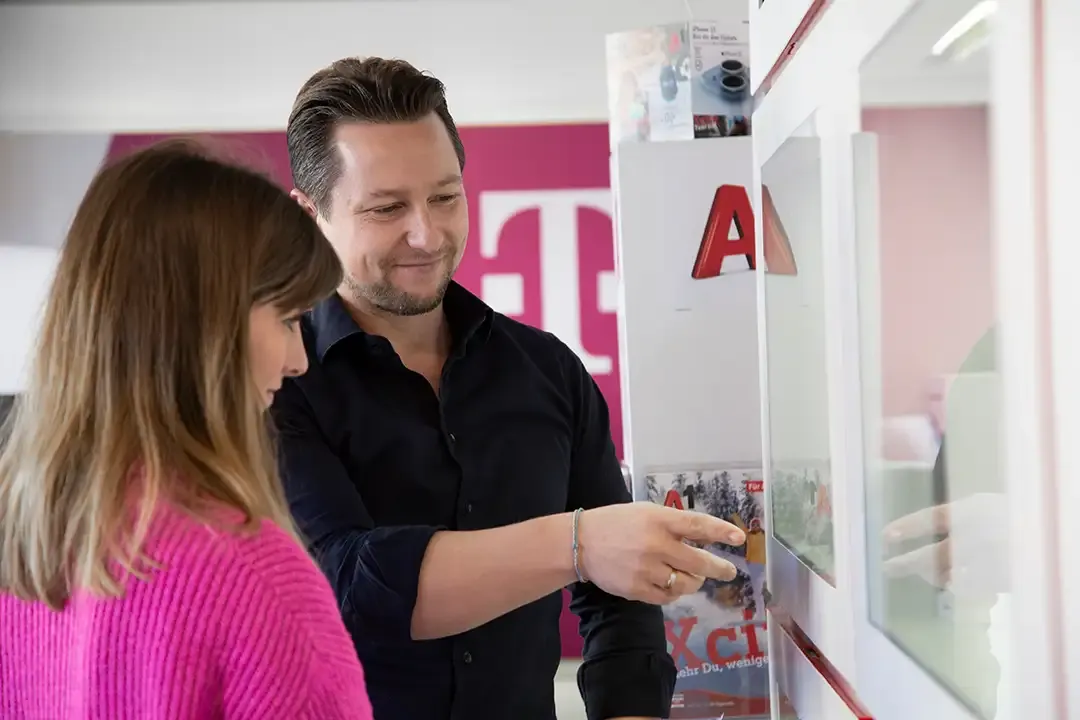 Ein Mann und eine Frau schauen auf einen Bildschirm.