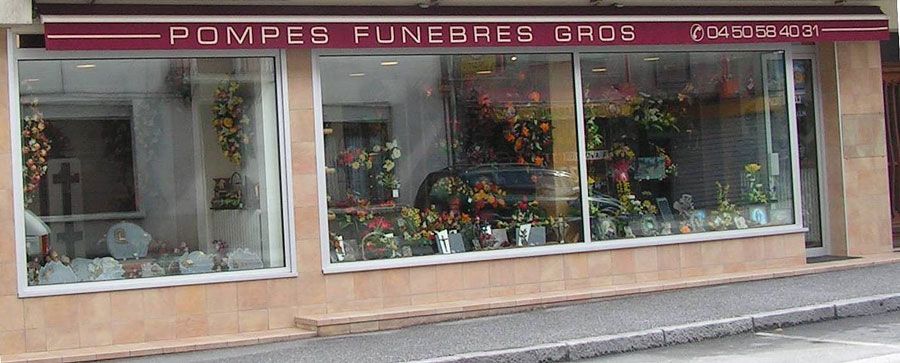 Vue extérieure d'une maison funéraire avec des compositions florales aux fenêtres.