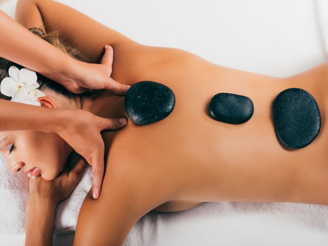 Una mujer está recibiendo un masaje con piedras calientes en un spa.