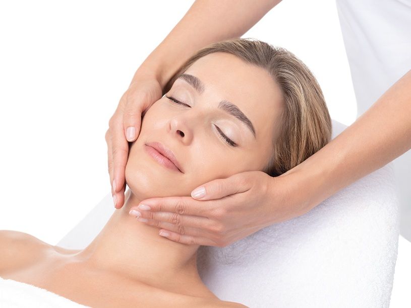 Una mujer está recibiendo un masaje facial en un spa.