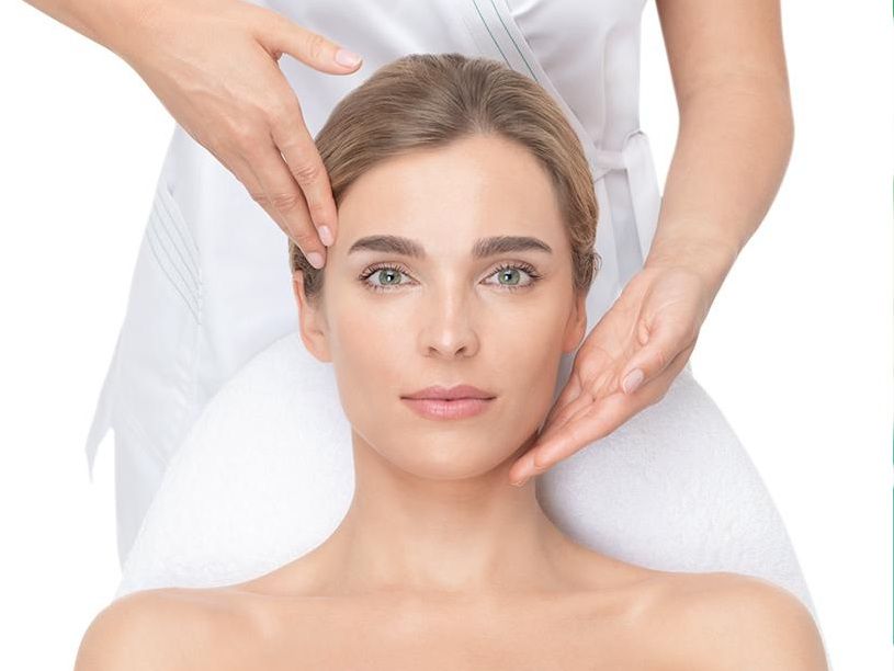 Una mujer está recibiendo un masaje de cabeza en un spa.