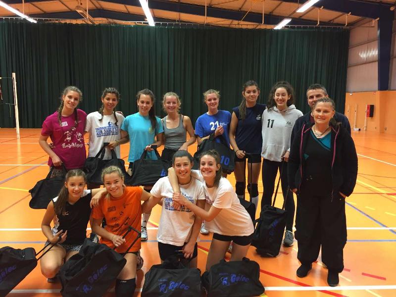 Photo d'équipe de face des volleyeuses de Rezé sur leur terrain en tenue de sport